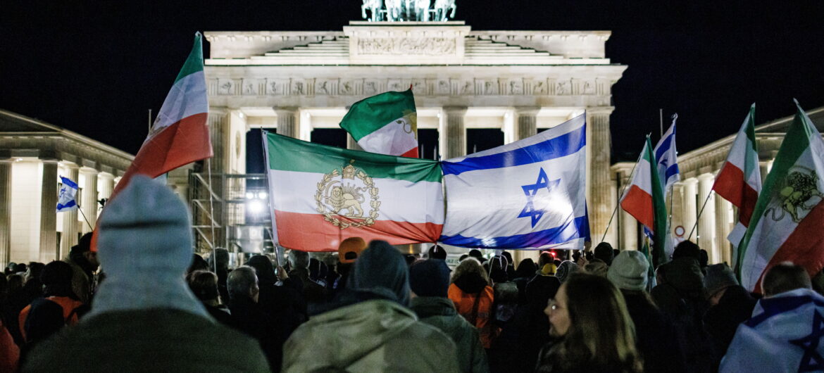Participants stand with flags of Israel and old Persian flags during a commemoration event one month after the Hamas attack on Israel in front of the Brandenburg Gate in Berlin, Germany, 07 November 2023. Thousands of Israelis and Palestinians have died since the militant group Hamas launched an unprecedented attack on Israel from the Gaza Strip on 07 October 2023 and the Israeli strikes on the Palestinian enclave that followed it. EPA/CLEMENS BILAN Dostawca: PAP/EPA.